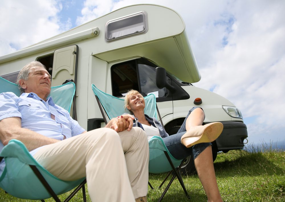 Senior couple relaxing in camping folding chairs camper in background.jpegkeepProtocol EarnFreeCashOnline